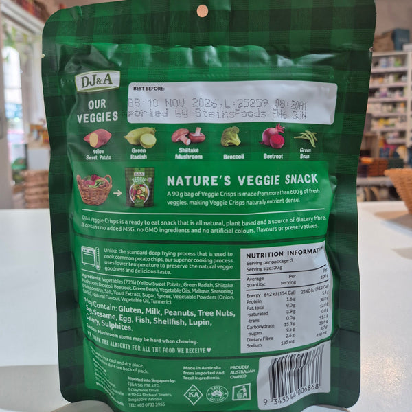 Green package of DJ&A Veggie Crisps with a bowl of colourful vegetables package with text and branding on a white surface
