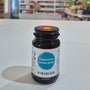 Viridian supplement bottle on a white surface with a blurred background of books and shelves.