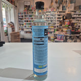 Cylindrical container with a blue label on a white surface, blurred background
