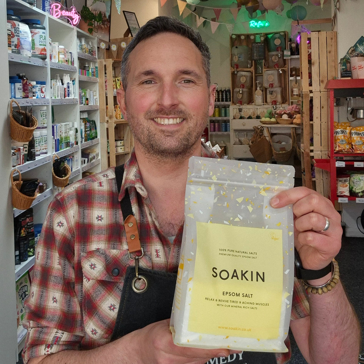 Man holding a package of Soakin Epsom salt in a store setting