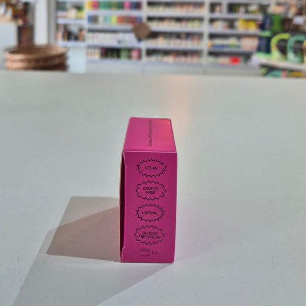 Pink deodorant refill box labeled 'fussy' on a counter with a store background.