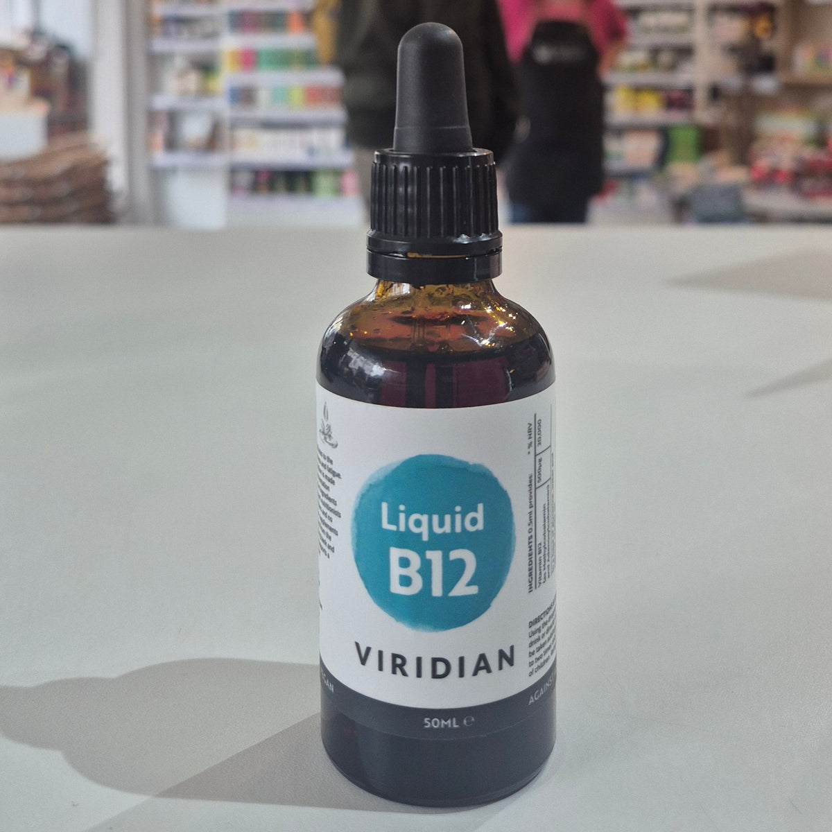 Bottle of Viridian Liquid B12 on a table with a blurred store background