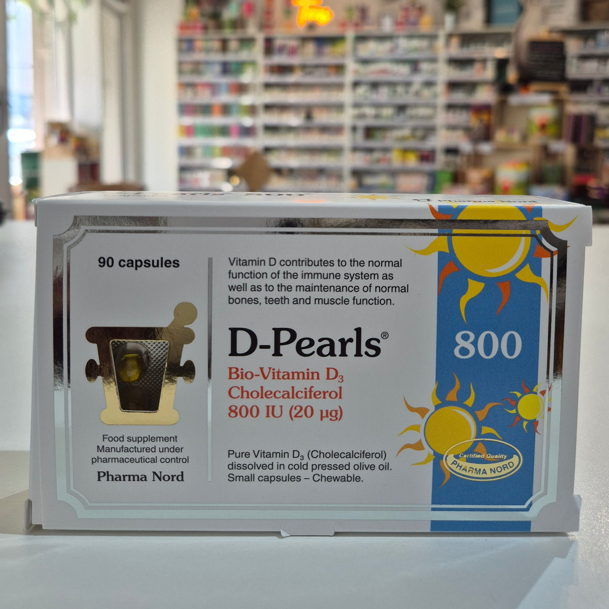 Box of D-Pearls Vitamin 800 D3 supplement with a blurred store background