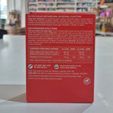 Red supplement box with text on a blurred indoor background