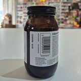 Brown glass jar with a label on a white surface, blurred store background
