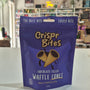 A purple stand-up pouch of Crispr Bites Milk Chocolate Filled Waffle Cones on a white countertop in a blurred retail shop setting.