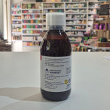 A dark amber glass bottle with a white cap and a white label, lying on a white surface with a blurred store interior in the background.