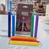 Colorful candles and books on a shelf with a blurred background