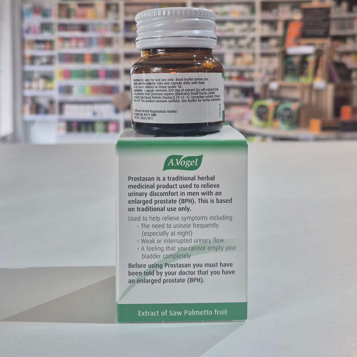A bottle and its packaging of A.Vogel Prostasan on a shelf in a pharmacy.