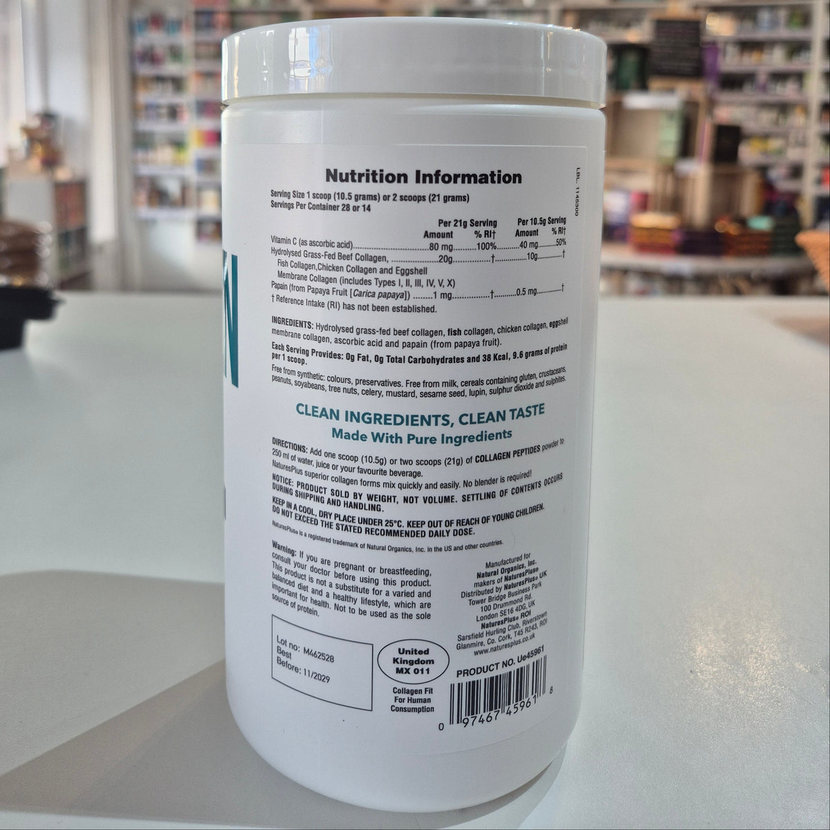 Close-up of a cylindrical container with text and a barcode, blurred background