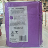 Purple package with text and a barcode on a blurred indoor background