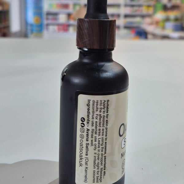 Black dropper bottle with a label on a white surface, blurred background
