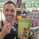 Man holding a Forest Feast snack package in a store setting