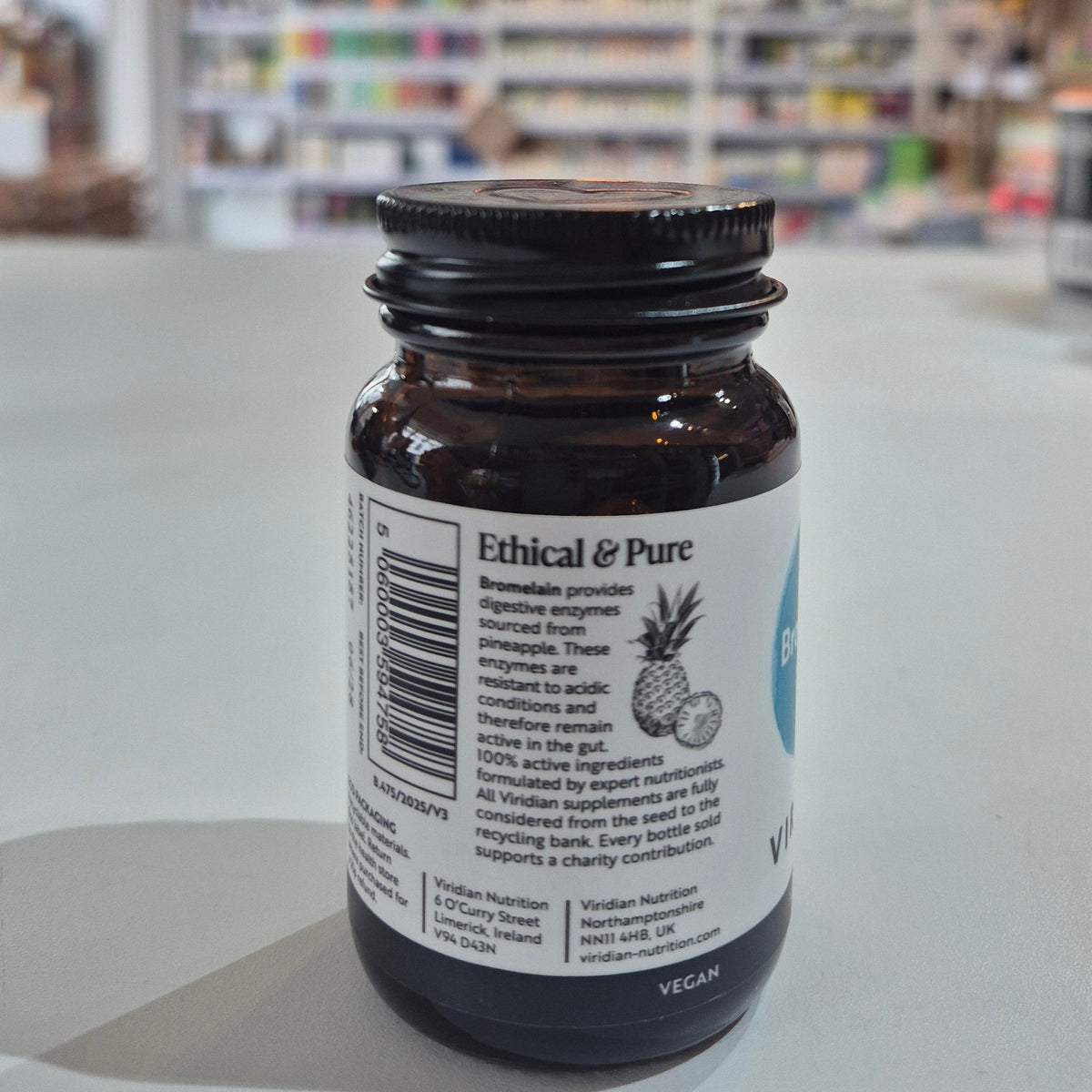 Bottle of Viridian Bromelain 500mg on a counter in a store setting with 'Ethical & Pure' label on a blurred store background