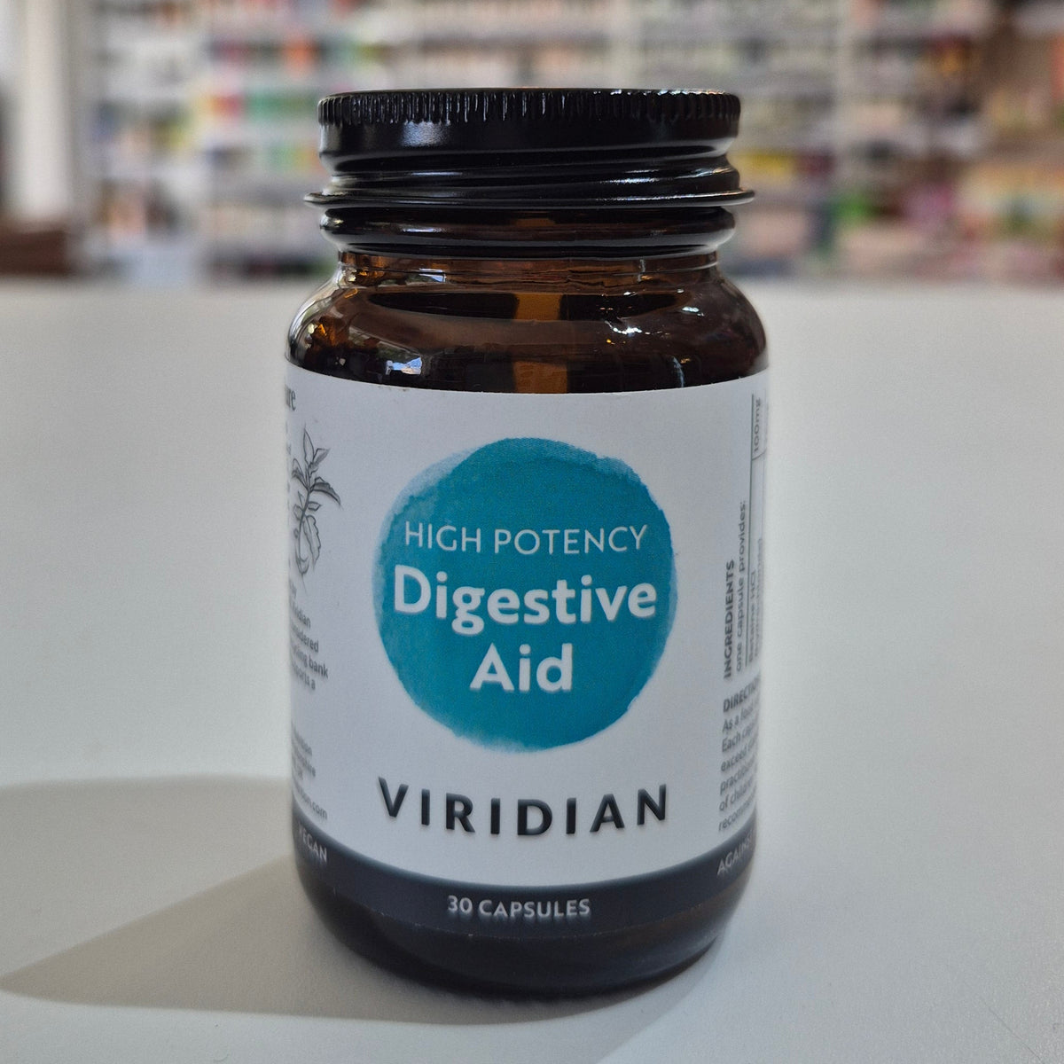Bottle of Viridian High Potency Digestive Aid on a white surface with a blurred background