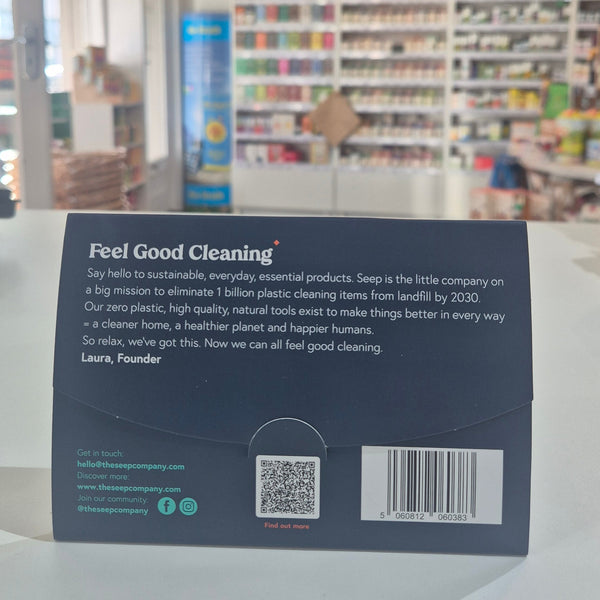 Product packaging with a barcode and text on a blurred background of books and shelves.