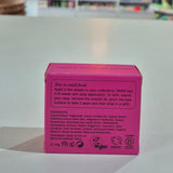 Pink deodorant box with text on a light gray surface