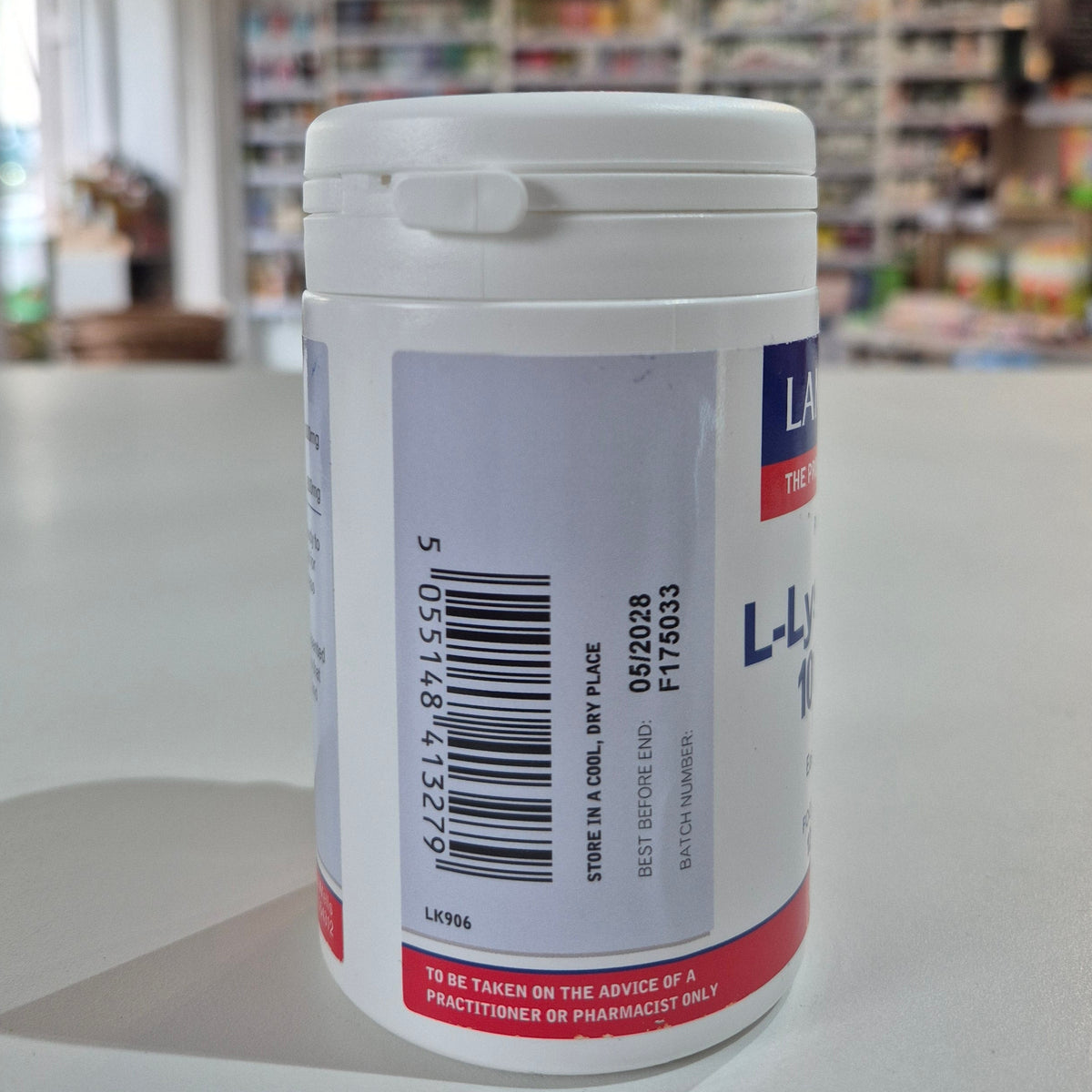Close-up of a cylindrical container with a label, blurred background