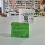 Fussy compostable deodorant refill container and packaging on a counter with a store background. Green and white boxes with text and a QR code on a surface with a store background