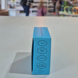 Fussy compostable deodorant refill packaging with a store in the background. Blue cosmetic box with certification labels on a blurred store background