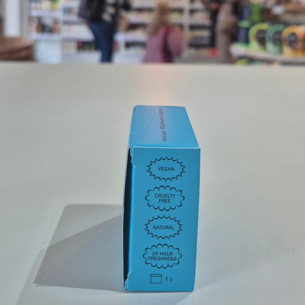 Fussy compostable deodorant refill packaging with a store in the background. Blue cosmetic box with certification labels on a blurred store background