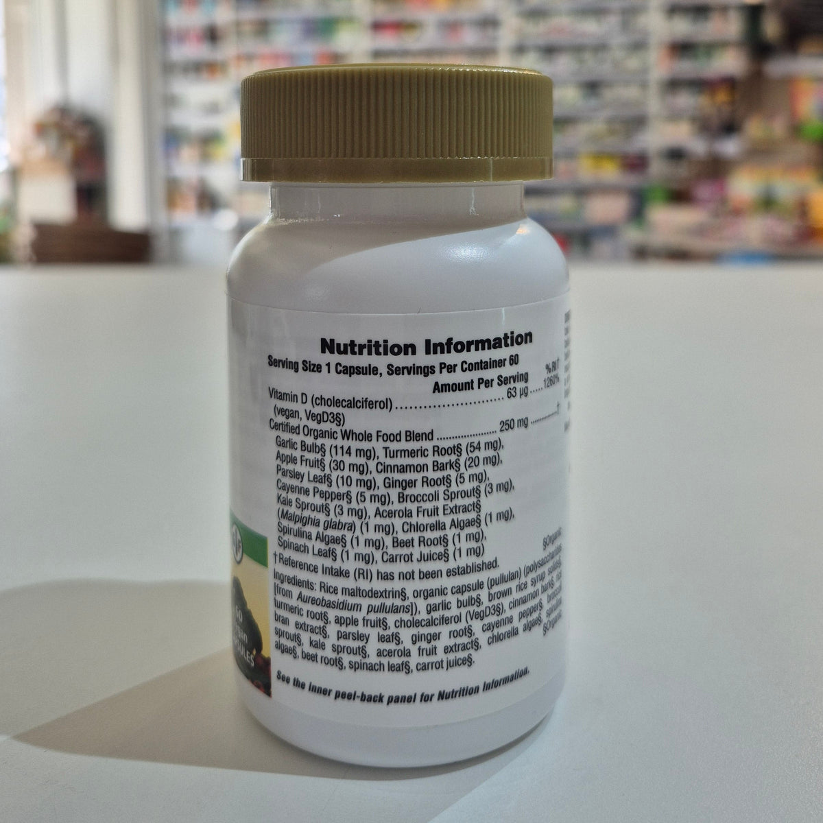 Nutritional information label on a supplement bottle with a blurred store background