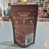 Pouch of peanut butter and milk chocolate dates on a counter with a blurred store interior in the background