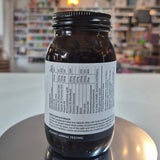 Jar of Viridian High Six B6 B Complex supplement on a counter with a blurred store background. Brown glass supplement bottle with label on a reflective surface in a store setting
