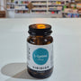Supplement bottle labeled 'Viridian L-Lysine' on a white surface with a blurred background of shelves.