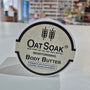 OatSoak body butter container with a blurred store background