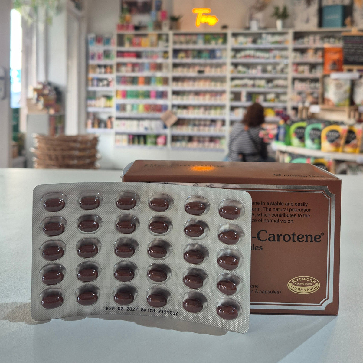 Pharmanord Supplement packaging with 'Carotene' on a counter in a store setting