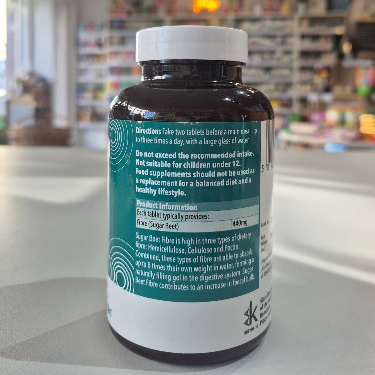Supplement bottle with label in a pharmacy setting