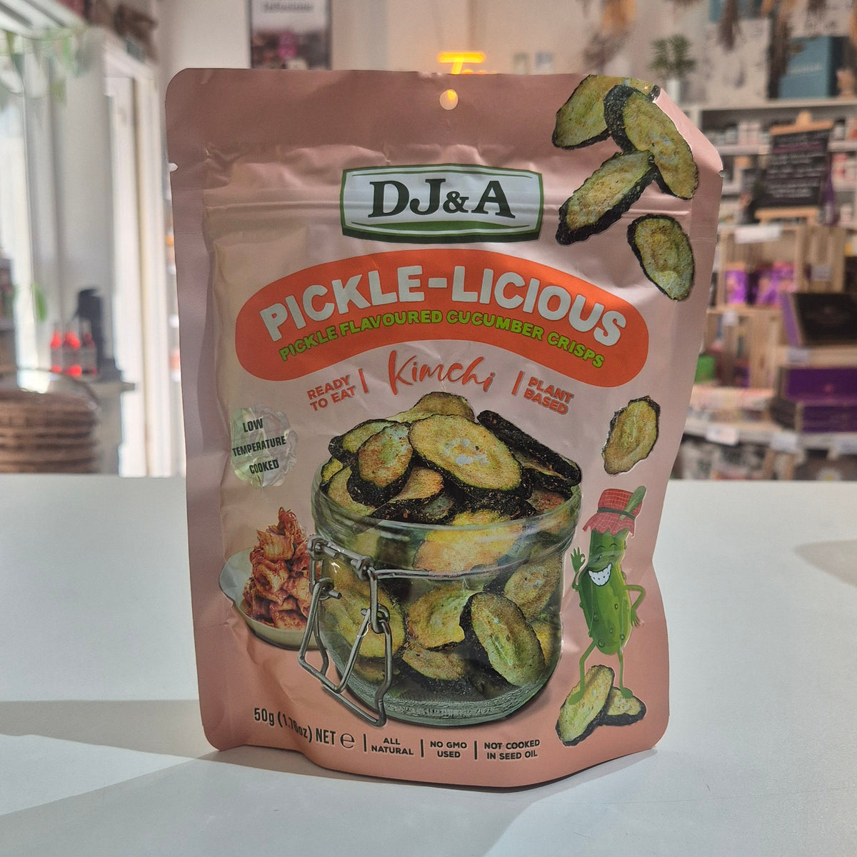 A stand-up pouch of DJ&A Pickle-Licious Kimchi pickles sitting on a white shop interior.