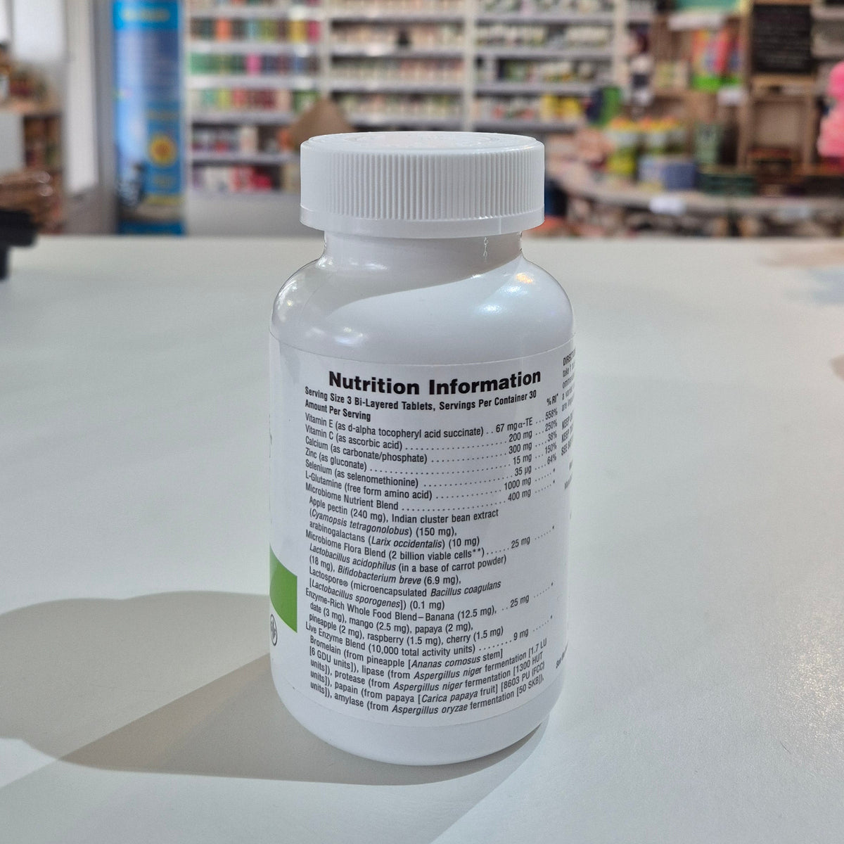 Bottle of nutritional supplement on a counter with a blurred store interior in the background