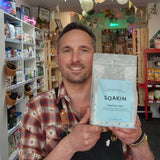 Man holding a Soakin product package in a store setting