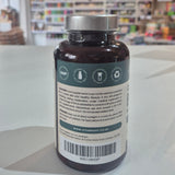Vitamins bottle with label on a white surface, blurred store background