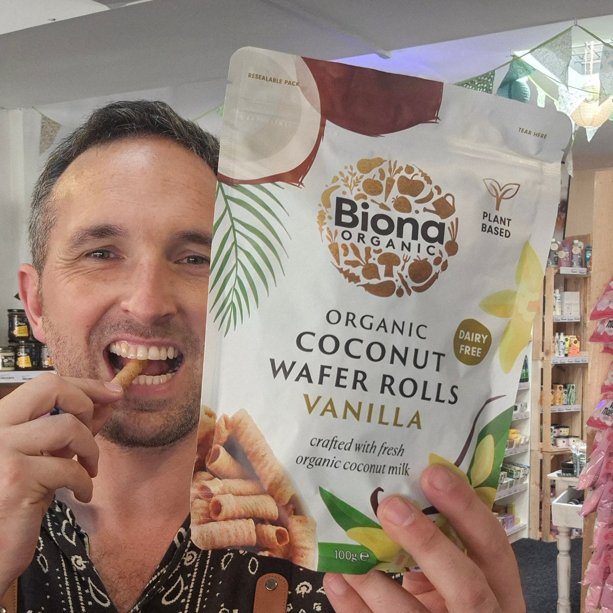 Man holding a package of Biona Organic Coconut Wafer Rolls Vanilla