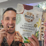 Man holding a package of Biona Organic Coconut Wafer Rolls Vanilla