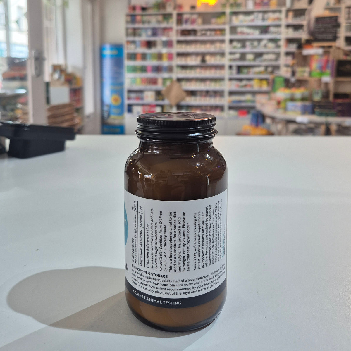 Brown bottle with label on a white surface, blurred background of store interior