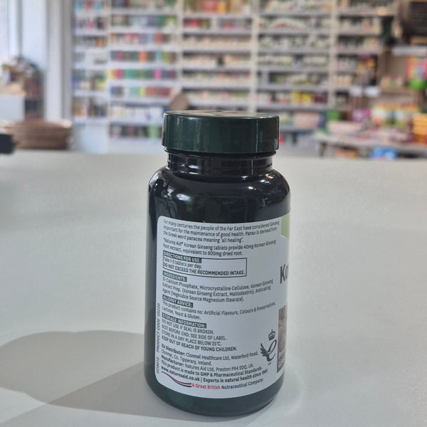 Bottle with label on a white surface with a blurred background of shelves with products.