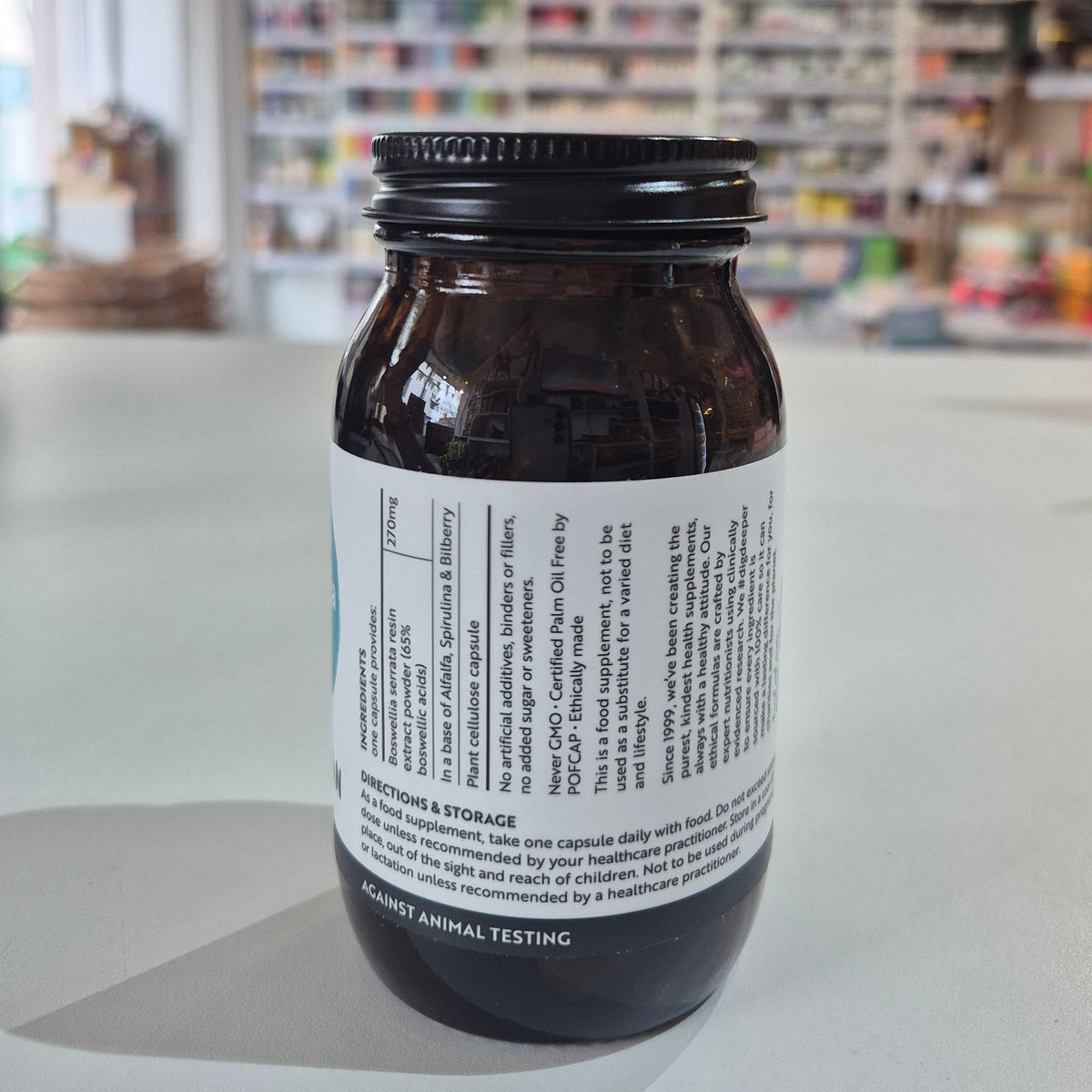 Side of bottle of Boswellia extract by Viridian on a white surface with a blurred background