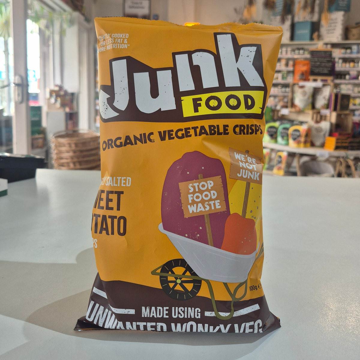 Junk Food Organic Vegetable Crisps packaging on a white surface with a blurred background