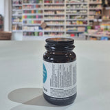 Brown glass bottle with a label on a white surface, blurred shelves in the background
