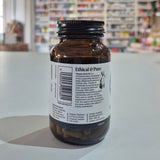 Brown bottle with a label on a white surface, blurred store shelves in the background