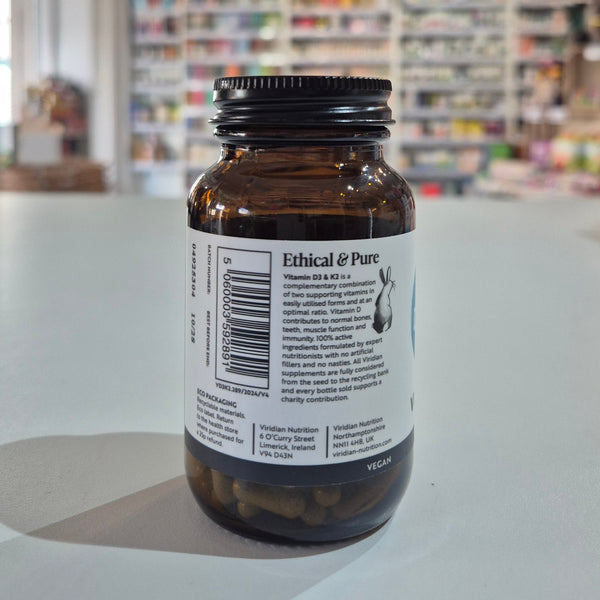 Brown bottle with a label on a white surface, blurred store shelves in the background