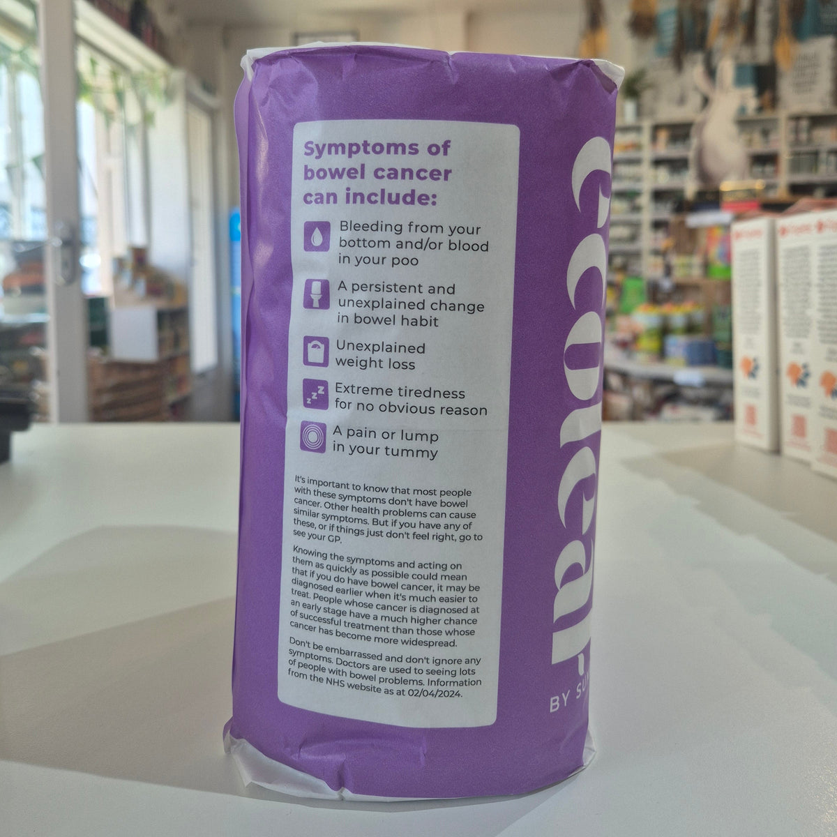 Purple package with text on a white surface,  in a store setting