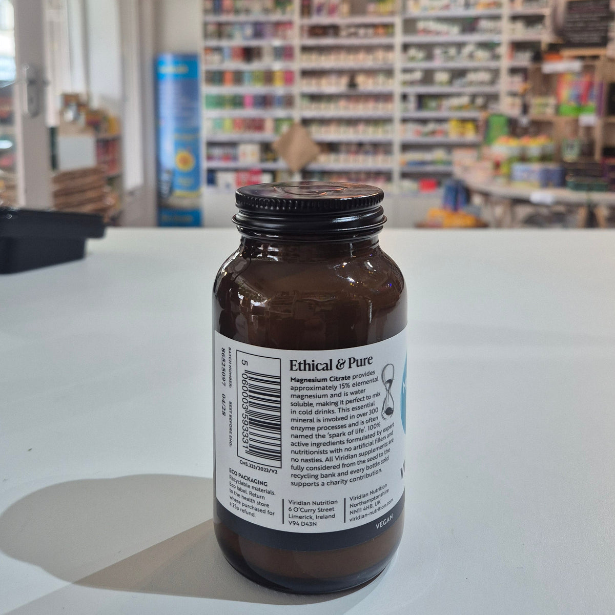 Small brown bottle with a label on a white surface, blurred background