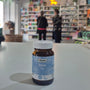 Bottle with a Boron label on a white surface, blurred store interior in the background