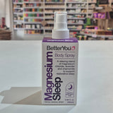 BetterYou Magnesium Sleep body spray bottle on a white surface with a store shelf in the background.