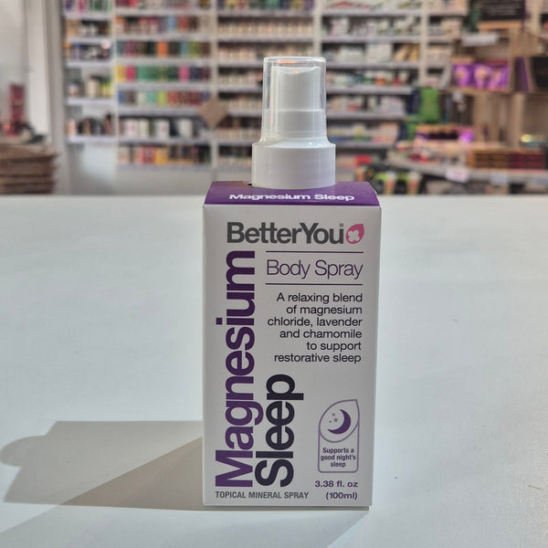 BetterYou Magnesium Sleep body spray bottle on a white surface with a store shelf in the background.